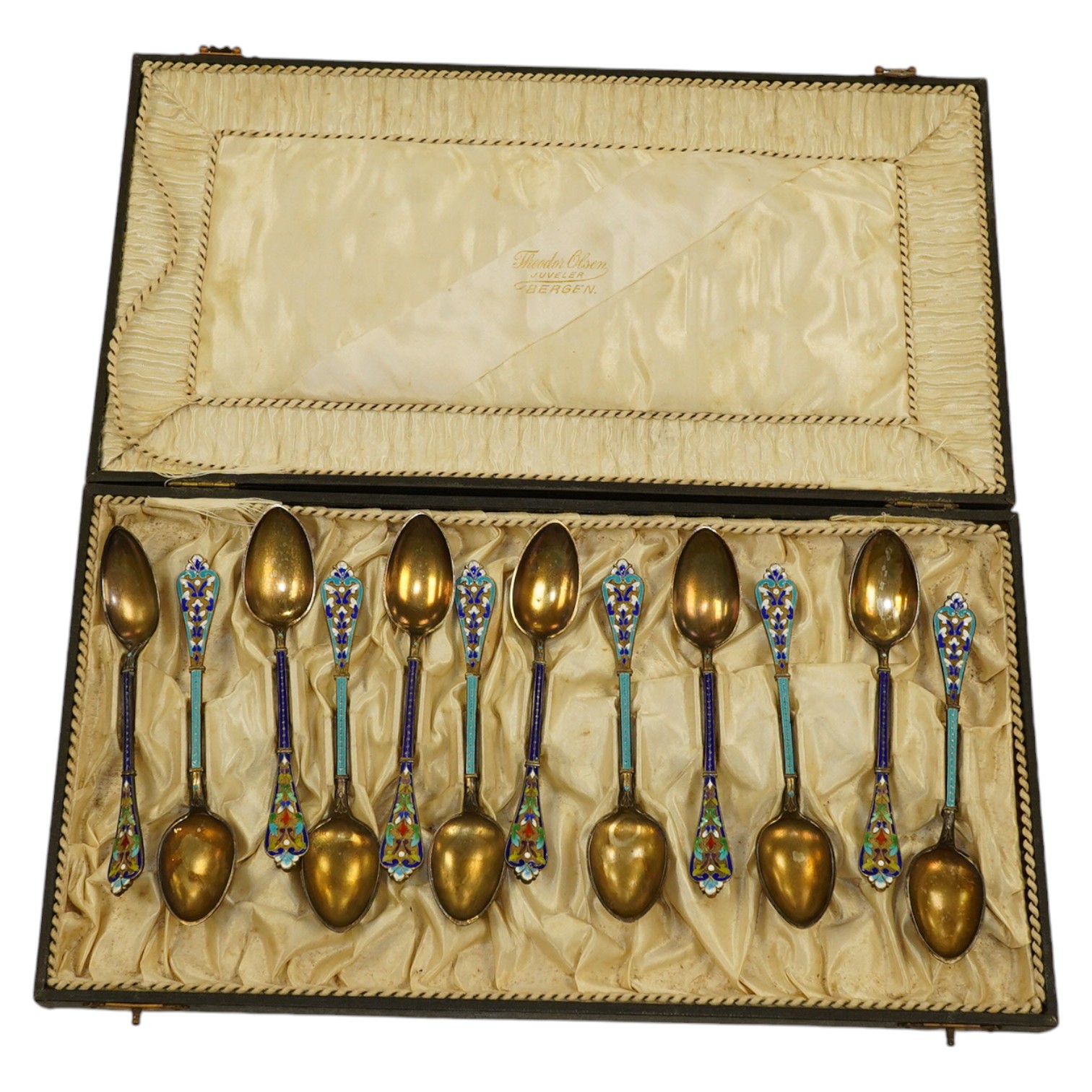 Two sets of Norwegian six enamelled gilt metal and cloisonné enamelled teaspoons, 11.9cm. Condition - poor to fair